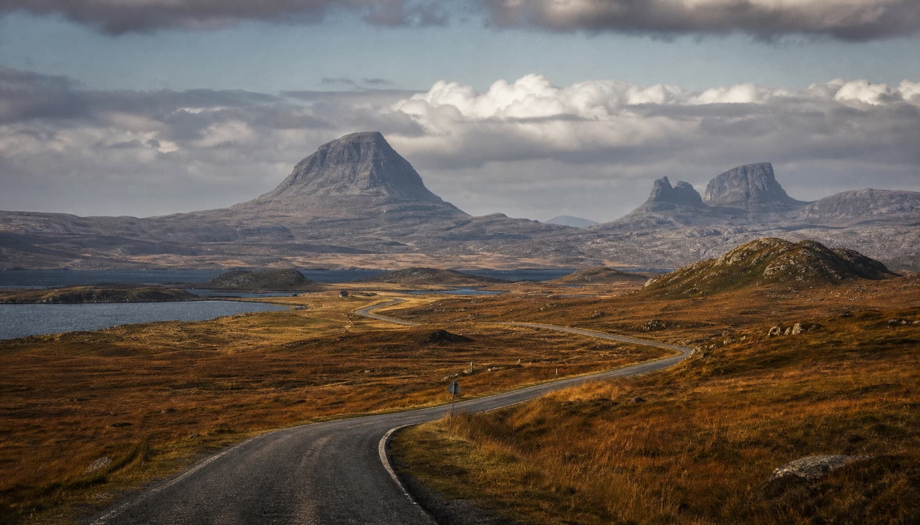 Single-track road winding through Assynt moorland below Suilven on the Durness to Ullapool drive