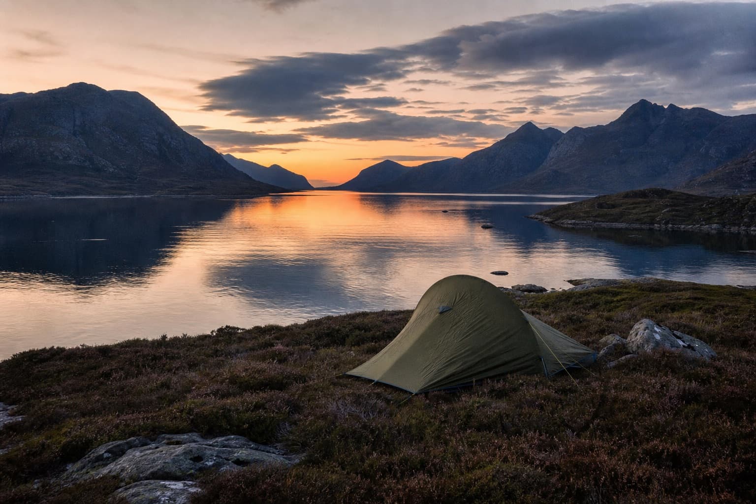 A single tent wild camping beside a calm Highland sea loch at dusk on the North Coast 500